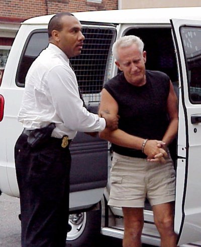 Corrections officer Mike Green, left, escorts convicted murderer Edward Solly from a van at Jersey State Prison in Trenton, N.J., Friday, May 18, 2001. Solly escaped in 1974 while on furlough from a New Jersey prison where he was serving time for murdering his girlfriend's 2-year-old son. Solly spent spent 27 years on the lam and posed as a doo-wop singer. (N.J. Department of Corrections)